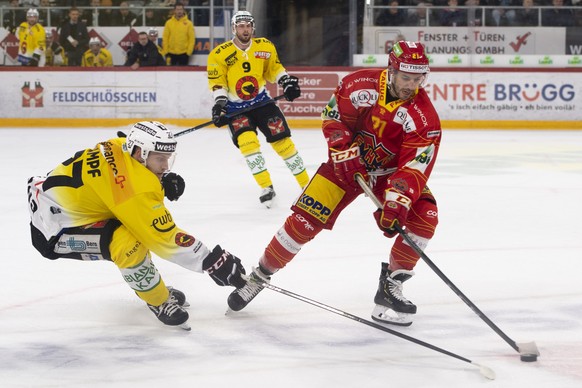 Berns Marc Kaempf, links, und Biels Jason Fuchs, rechts, kaempfen um den Puck an der Seite Berns Jan Mursak, Mitte, beim Eishockey Meisterschaftsspiel der National League zwischen dem HC Biel und dem  ...