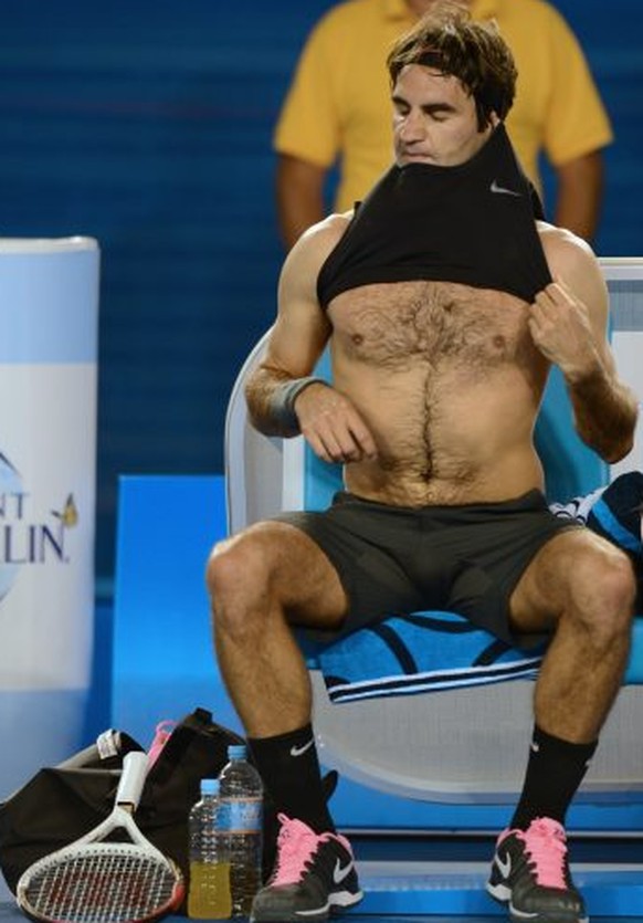 Switzerland&#039;s Roger Federer changes his shirt during his men&#039;s singles match against France&#039;s Jo-Wilfried Tsonga on the tenth day of the Australian Open tennis tournament in Melbourne o ...