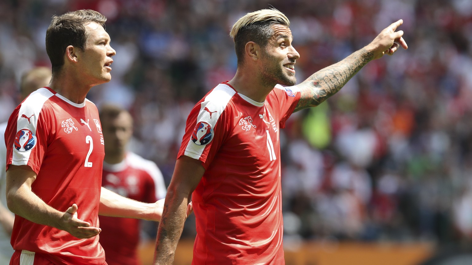 Switzerland&#039;s Stephan Lichtsteiner, left, and Valon Behrami gesture during the Euro 2016 round of 16 soccer match between Switzerland and Poland, at the Geoffroy Guichard stadium in Saint-Etienne ...