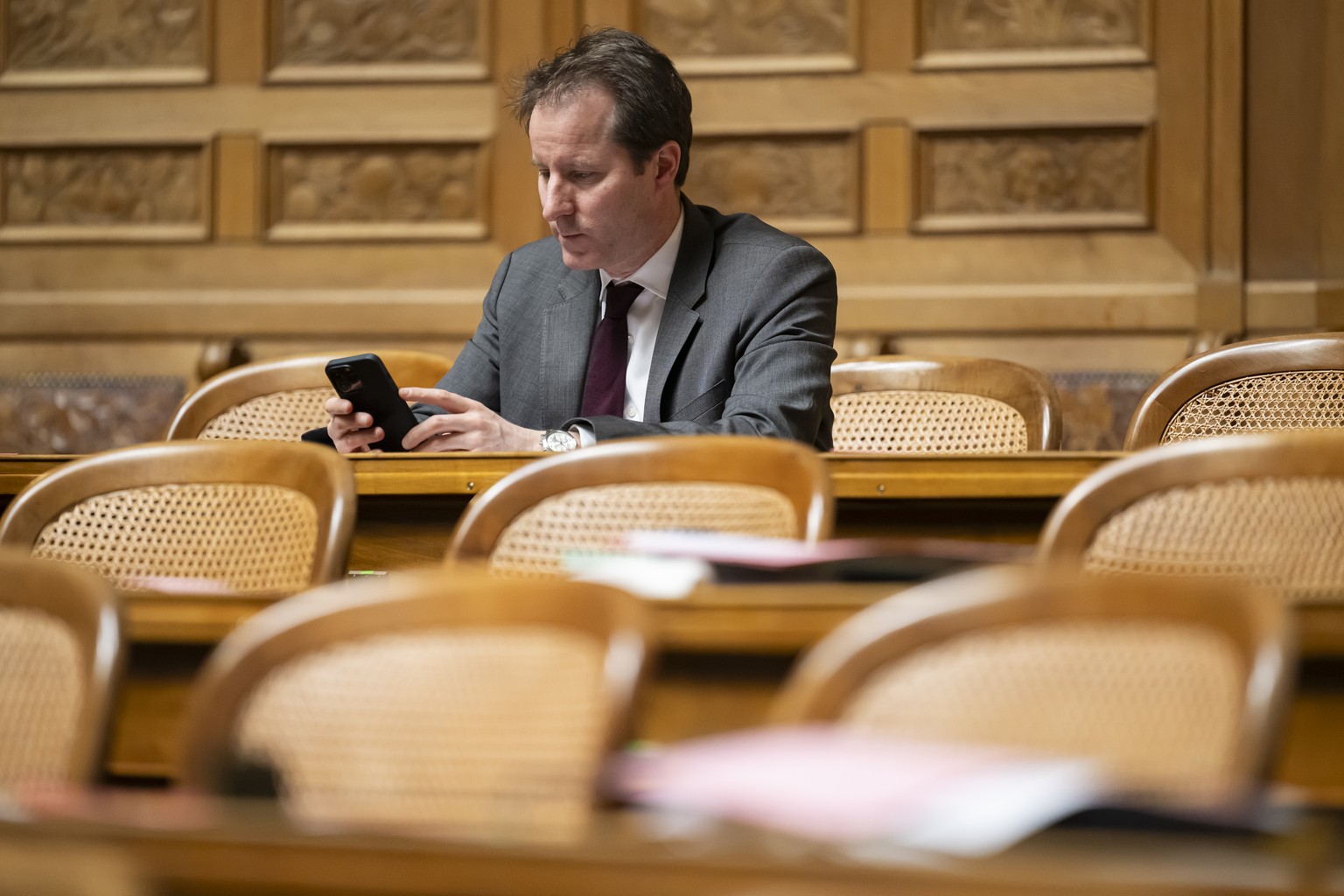 Thomas Aeschi, SVP-ZG, schaut auf sein Handy waehrend der Fruehlingssession der Eidgenoessischen Raete, am Dienstag, 5. Maerz 2024 im Nationalrat in Bern. (KEYSTONE/Anthony Anex)