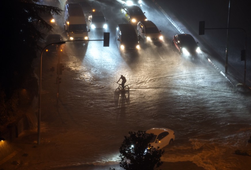 A cyclist rides through floodwater blocking the road due to heavy rain in Basaksehir district of Istanbul, Turkey, Tuesday, Sept. 5, 2023. Flash floods triggered by heavy rains swept through a campsit ...