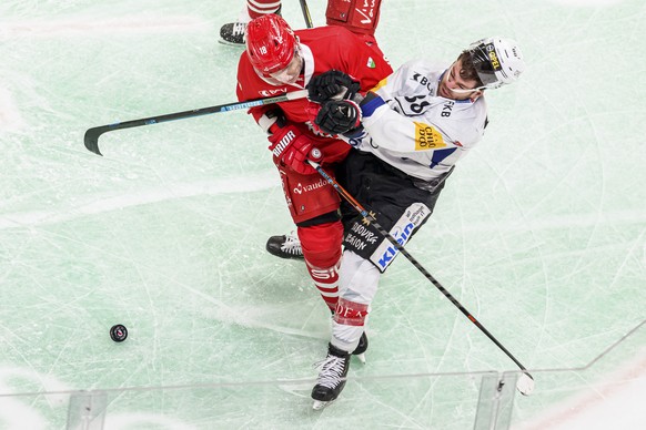 L&#039;attaquant lausannois Floran Douay, gauche, lutte pour le puck avec l&#039;attaquant fribourgeois Christopher DiDomenico, droite, lors du match a huis clos du championnat suisse de hockey sur gl ...