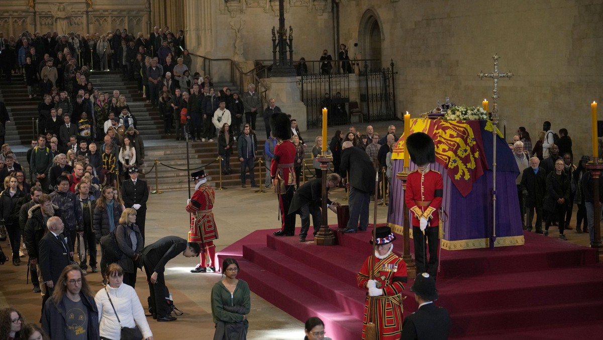Members of the public file past the coffin of Queen Elizabeth II, draped in the Royal Standard with the Imperial State Crown and the Sovereign's orb and sceptre, lying in state on the catafalque  ...