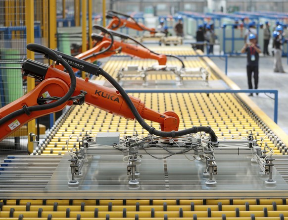 Kuka robots work on the production line of flat glass for solar panels at a subsidiary plant of Hoshine Silicon Industry in northwestern China&#039;s Xinjiang Uyghur Autonomous Region Friday, May 24,  ...