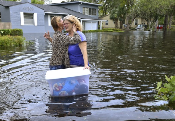 Charlotte Glaze gives Donna Lamb a teary hug as she floats out some of her belongings in floodwaters from the Ortega River in Jacksonville, Fla., Monday, Sept. 11, 2017, after Hurricane Irma passed th ...