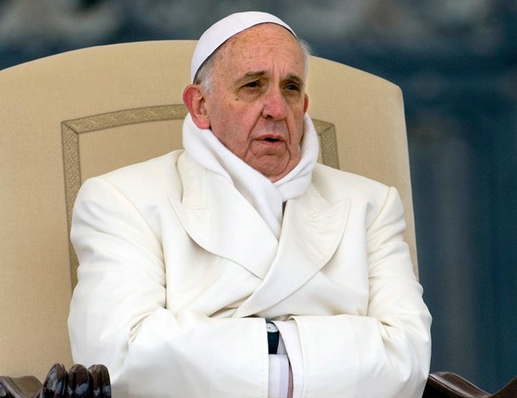 FILE - In this Wednesday, Nov. 27, 2013 file photo Pope Francis tries to keep himself warm as he attends his weekly general audience in St. Peter's Square at the Vatican. (AP Photo/Alessandra Tar ...