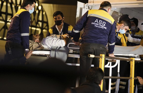 Workers take out a medical stretcher with a wounded member of the Azerbaijan Embassy in Iran&#039;s capital from the bus upon arrival at an airport outside Baku, Azerbaijan, Sunday, Jan. 29, 2023. A g ...