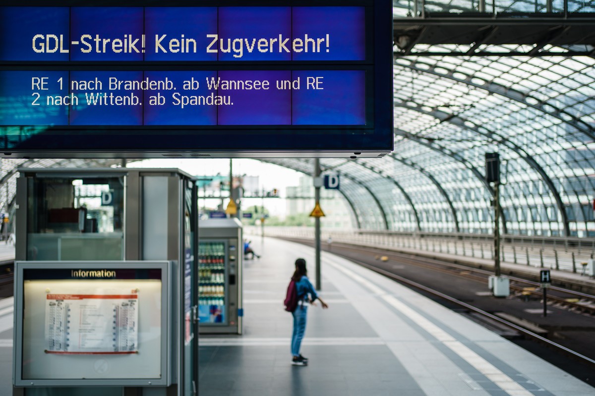 epa09409488 A display reads 'GDL strike - no train service', while a passenger waits on a nearly deserted platform during a warning strike in railway operations in Germany at Berlin Central  ...