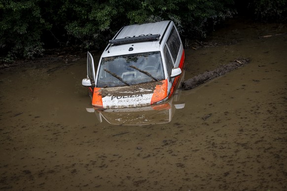 epa11432532 A police vehicle is stuck in the water after two police officers rescued themselves by swimming, caused by severe weather and heavy rain in the Misox valley, in Cama village, Lostallo, sou ...