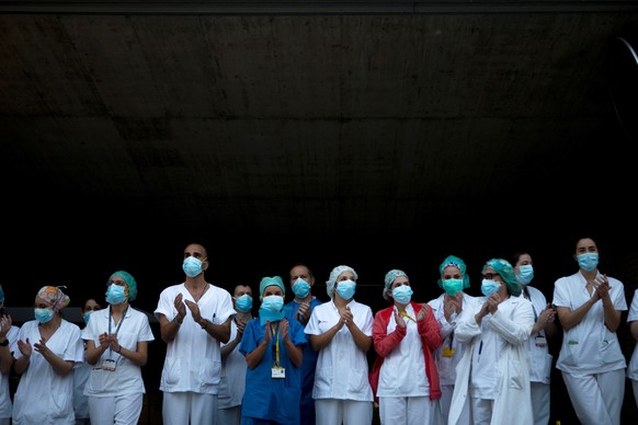 epa08358001 Members of the sanitary personnel clap during the daily gratitude applause for medical and health care personnel from a Saint Paul Hospital in Barcelona, Catalonia, Spain, 11 April 2020. S ...