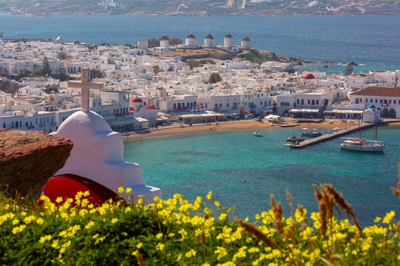 Mykonos town and harbor with windmills, white houses and turquoise sea seen from a church viewpoint on a sunny day Copyright: xkavalenkavax Panthermedia102368448.jpg