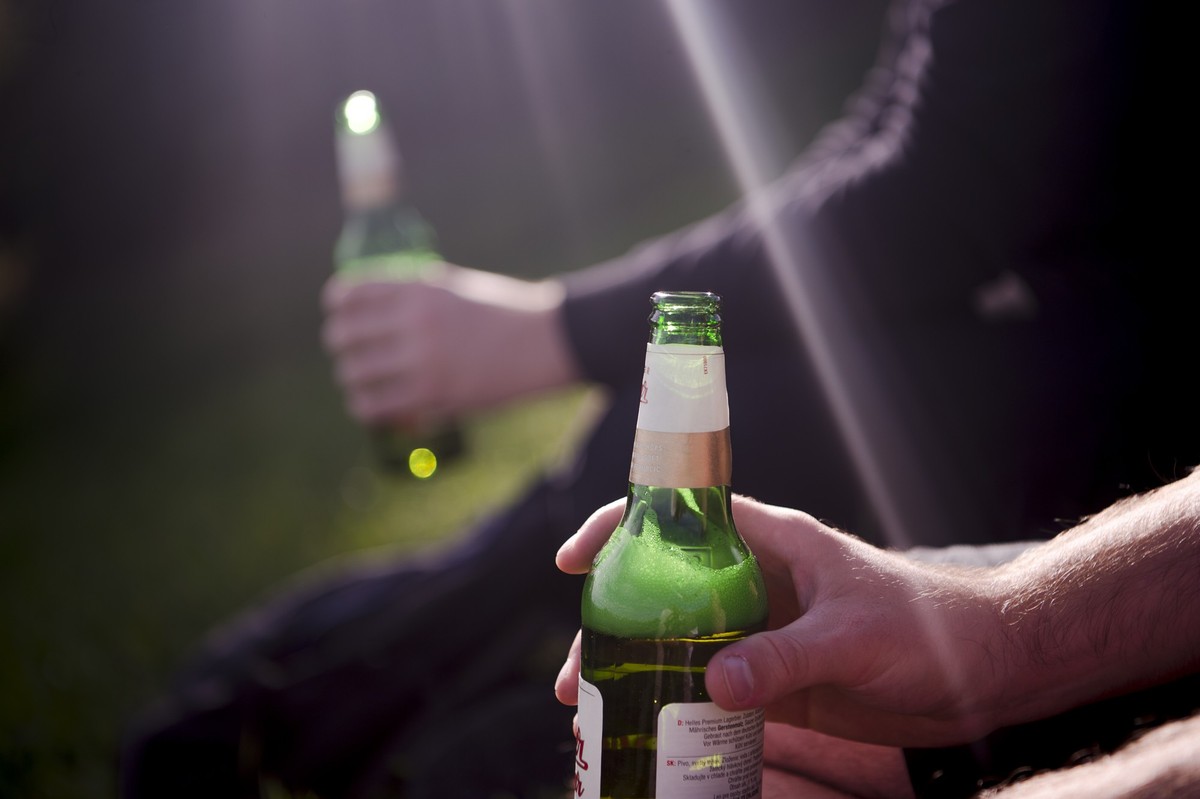 PRODUKTION - 03.10.2021, Bayern, M�nchen: Zwei M�nner sitzen im Olympia-Park und trinken Bier. (zu dpa �Vorstellung des DKV-Reports 2021 �Wie gesund lebt Deutschland?��) Foto: Finn Winkler/dpa +++ dpa ...