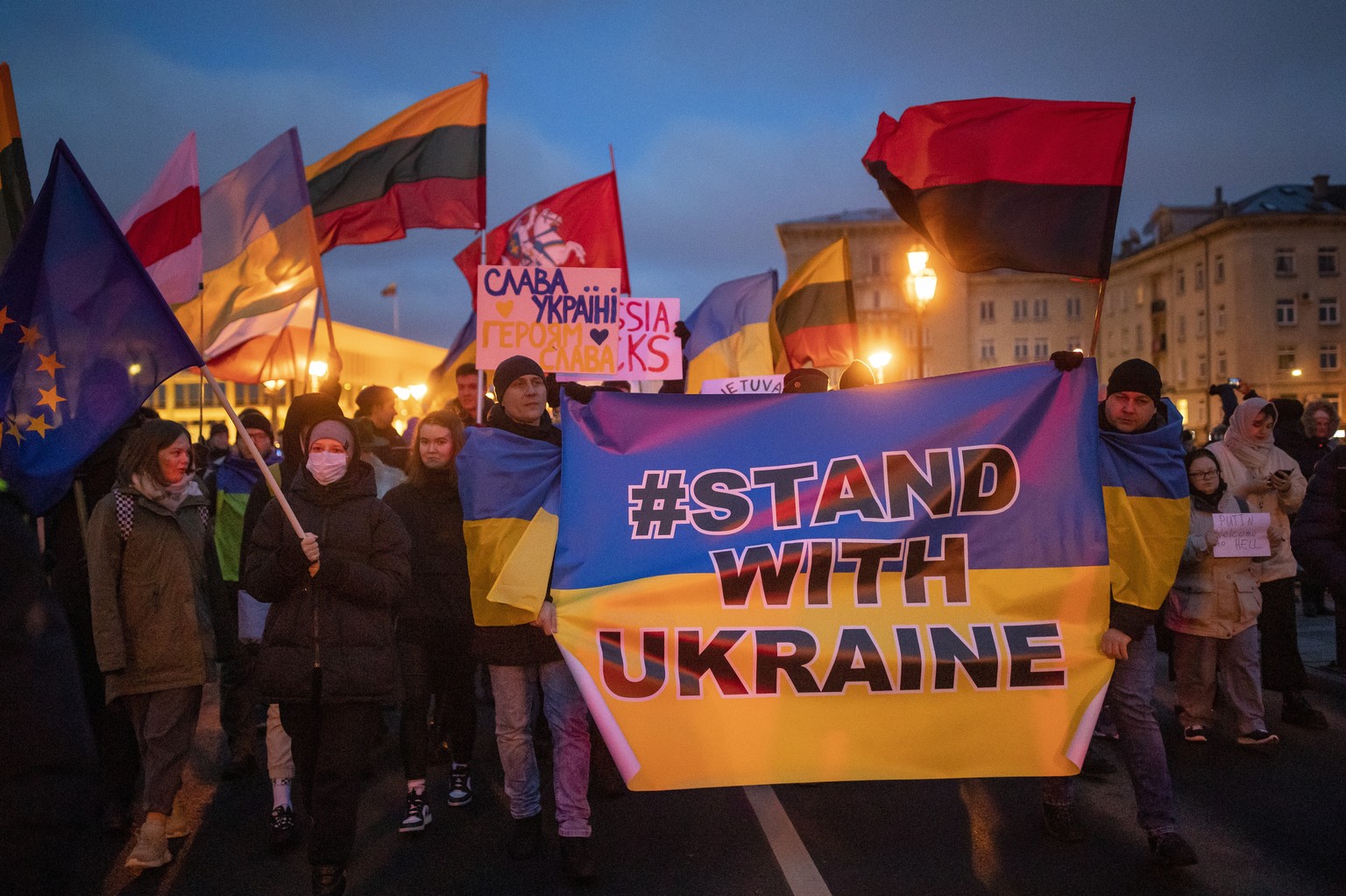 People carry placards and wave flags during a protest against Russian attacks in Ukraine along the street near the Russian embassy in Vilnius, Lithuania, Thursday, Feb. 24, 2022. Russian troops launch ...