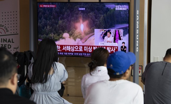 epa12994191 People watch the news on a television screen at a station in Seoul, South Korea, 26 May 2026. According to South Korea's Joint Chiefs of Staff (JCS), North Korea launched several ball ...