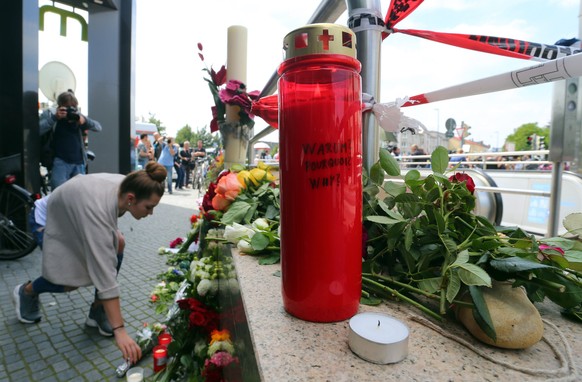 epa05437780 People lay flowers at the entrance to the underground station Olympia shopping center which was the scene of a shooting spree in Munich, Germany, 23 July 2016. According to authorities, at least 10 people died, including the suspect, after a shooting spree at the Olympia shopping centre in Munich on 22 July 2016. Police on 23 July 2016 said it was a 'classical amok run' by an 18-year-old Munich-born young man.  EPA/KARL-JOSEF HILDENBRAND