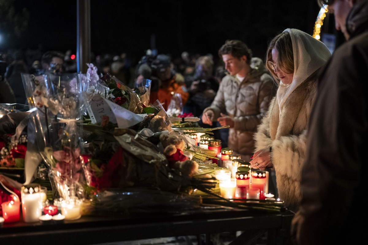 epa12621044 Several hundred mourners gather to lay down flowers and light candles to remember the victims of the fire at the "Le Constellation" bar and lounge, which left people dead and inj ...