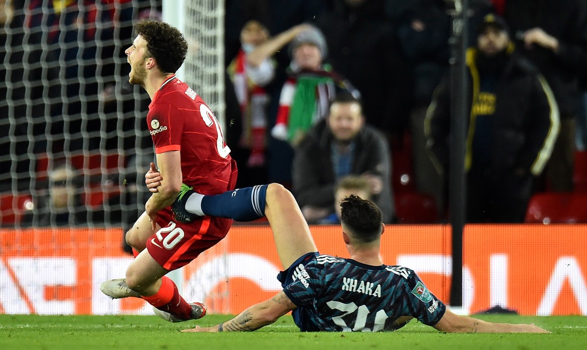 epa09683803 Granit Xhaka (R) of Arsenal fouls Diogo Jota of Liverpool during the English Carabao Cup semi final, first leg soccer match between Liverpool FC and Arsenal FC in Liverpool, Britain, 13 Ja ...