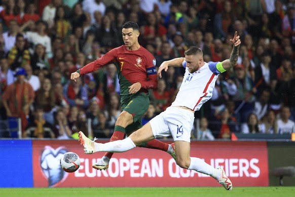 Portugal&#039;s Cristiano Ronaldo vies for the ball with Slovakia&#039;s Milan Skriniar, right, during the Euro 2024 group J qualifying soccer match between Portugal and Slovakia at the Dragao stadium ...