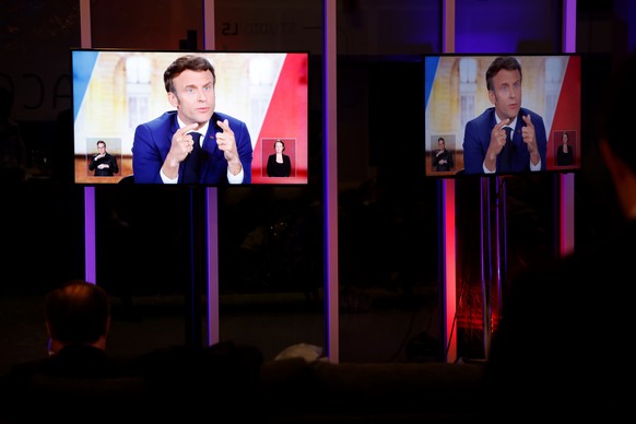 epa09899515 A picture shows a TV screen displaying French President and La Republique en Marche (LREM) party candidate for re-election Emmanuel Macron during a live televised debate with French far-ri ...