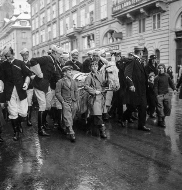 Studenten der Zofingia sind mit dem Weihnachtsesel in Bern unterwegs und verteilen Geschenke an die Kinder, aufgenommen im Dezember 1937. (KEYSTONE/PHOTOPRESS-ARCHIV/Str)