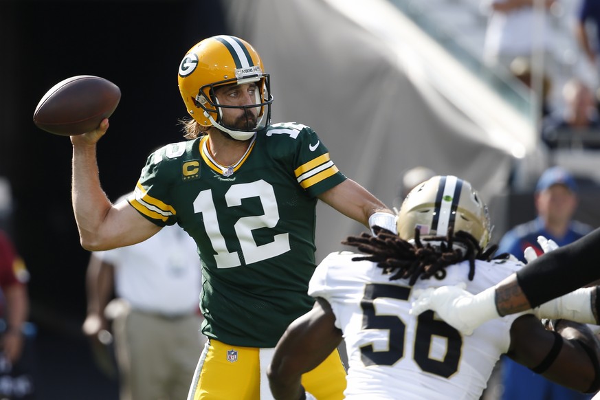 Green Bay Packers quarterback Aaron Rodgers (12) throws a pass as New Orleans Saints outside linebacker Demario Davis (56) rushes during the first half of an NFL football game, Sunday, Sept. 12, 2021, ...