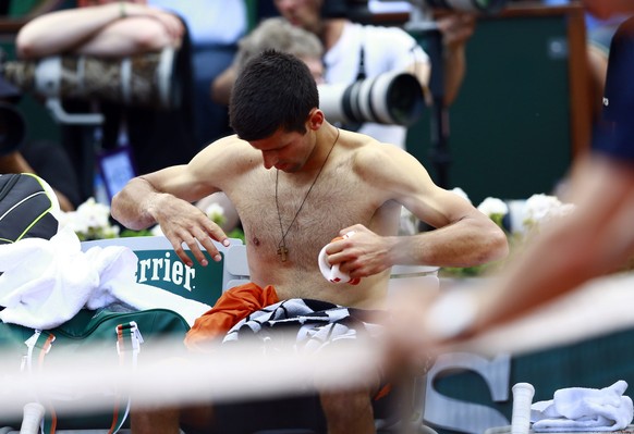 epa04784873 Novak Djokovic of Serbia changes his shirt during a break as he plays Andy Murray of Britain during their semifinal match for the French Open tennis tournament at Roland Garros in Paris, F ...