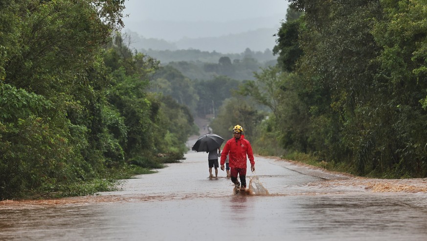 epa11314435 A handout photo made available by the Government of Rio Grande Do Sul shows people wading through the floods caused by heavy rains in Rio Pardinho, Brazil, 01 May 2024 (issued 02 May 2024) ...