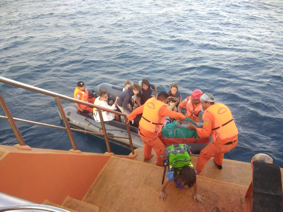 Touristen klettern auf ein Rettungsboot.