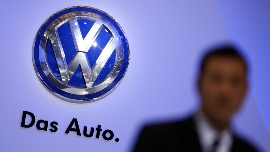 A security guard stand next to a Volkswagen logo at the stage of the company prior to the opening of the 15th Shanghai International Automobile Industry Exhibition in this April 19, 2013 file photogra ...