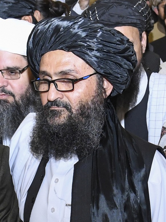 epa09454063 (FILE) - Taliban co-founder Mullah Abdul Ghani Baradar (R) leaves after signing an agreement with the United States during a ceremony in Doha-Qatar on 29 February 2020 (reissued 07 Septemb ...