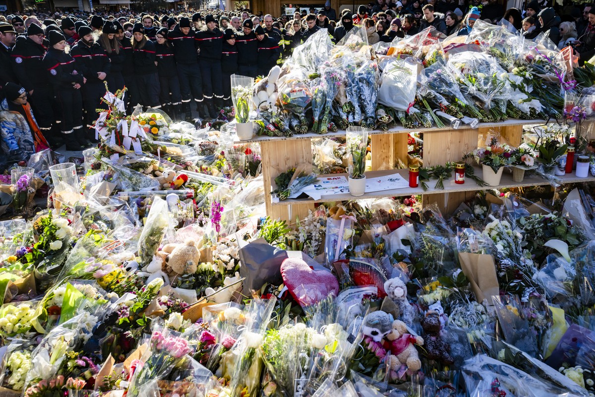 The firefighters, sapeurs-pompiers de Crans-Montana, first responders in the fire at the "Le Constellation" bar and lounge, show emotions as they gather around flowers and candles to commemo ...