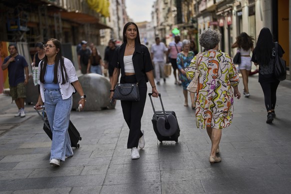 FILE - Tourists carry their luggage in downtown Madrid, Spain, June 3, 2025. (AP Photo/Manu Fernandez, File)
Spain Airbnb