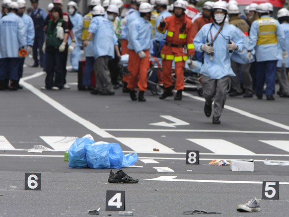 FILE - Shoes of victims are left on a street as rescuers from the Tokyo Metropolitan Police Department work in Tokyo&#039;s Akihabara district after a man rammed a truck into a crowd of shoppers, jump ...