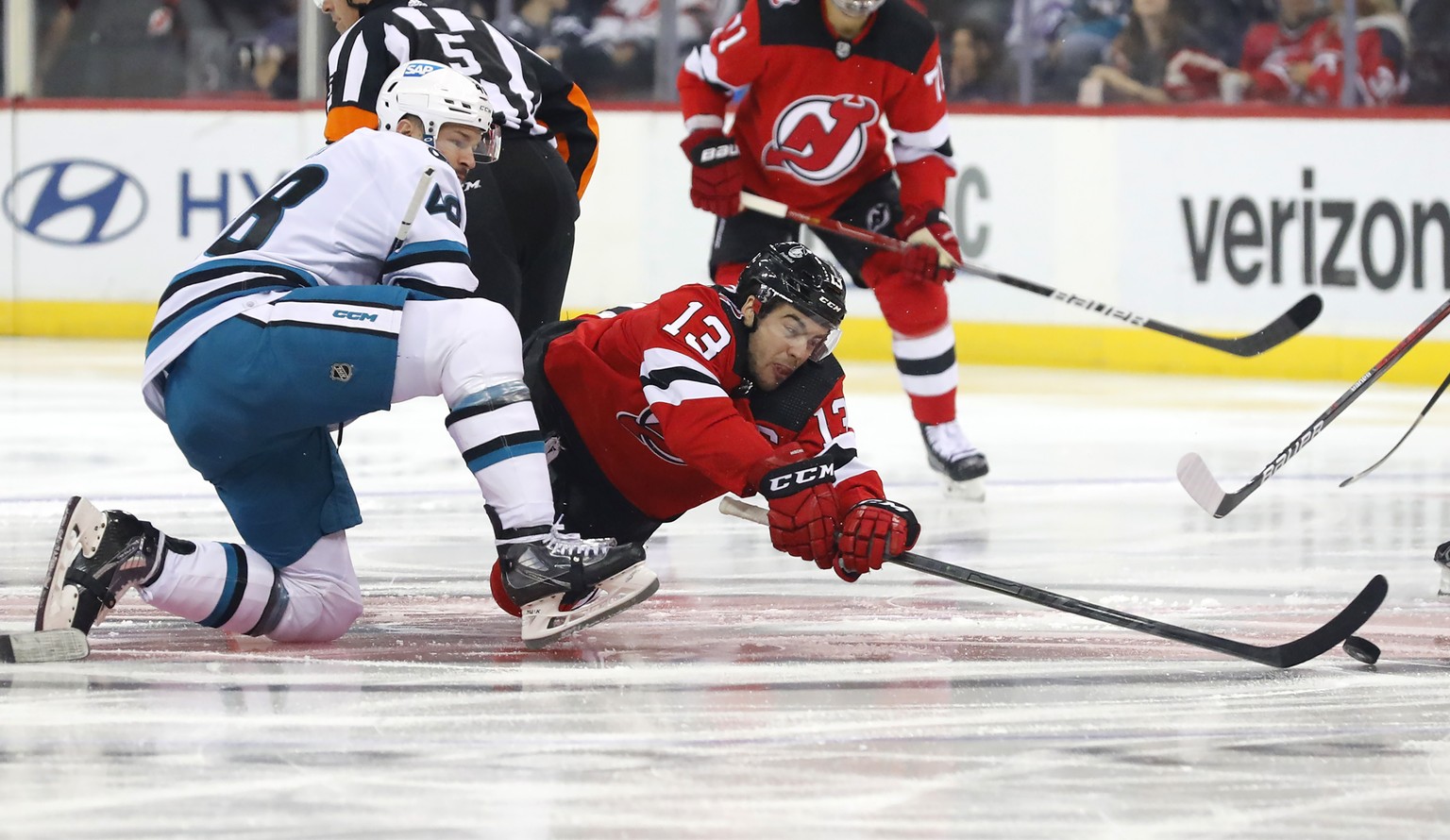 New Jersey Devils center Nico Hischier (13) plays the puck against San Jose Sharks center Tomas Hertl(48) during the first period of an NHL hockey game, Saturday, Oct. 22, 2022, in Newark, N.J. (AP Ph ...