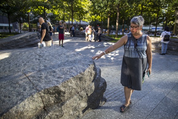 In this Thursday, Aug. 29, 2019, photo a visitor touches one of the granite slabs at the 9/11 Memorial Glade at the National September 11 Memorial &amp; Museum in New York. When the names of nearly 3, ...