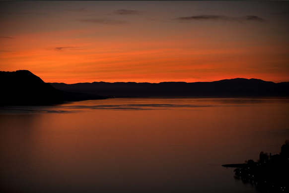 Abendrot: Die rote Farbe am Abendhimmel entsteht durch die Streuung des Sonnenlichts. Die Sonne geht über dem Genfer See und den Schweizer und französischen Alpen über Montreux in der Südwestschweiz u ...