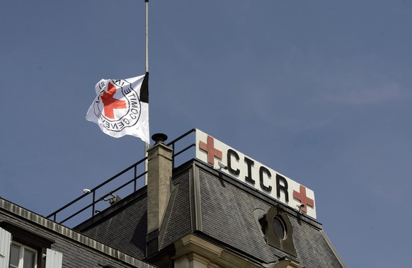 epa04240686 The International Committee of the Red Cross (ICRC), flag is raised to half-mast in honour of the Swiss ICRC staff member who was killed, the previous day, in the Libyan city of Sirte, in  ...