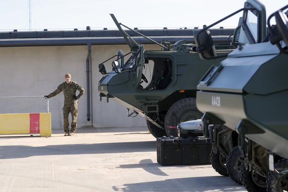 epa09887500 Latvian Army serviceman looks at a Finnish/Latvian Patria 6x6 vehicle during his visit to Adazi military base, Latvia, 13 April 2022. Peter Hultqvist pays a visit to Latvia to discuss regi ...