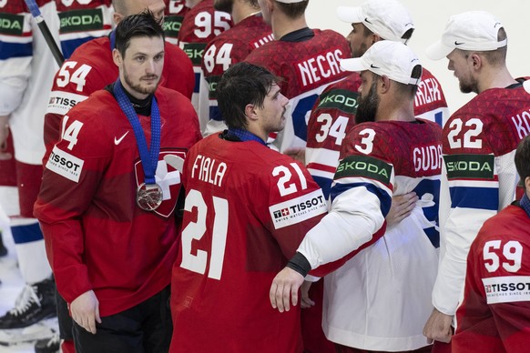 Switzerland&#039;s Dean Kukan, left, and Switzerland&#039;s Kevin Fiala react with the silver medal during the Ice Hockey World Championship final match between Switzerland and Czech Republic in Pragu ...
