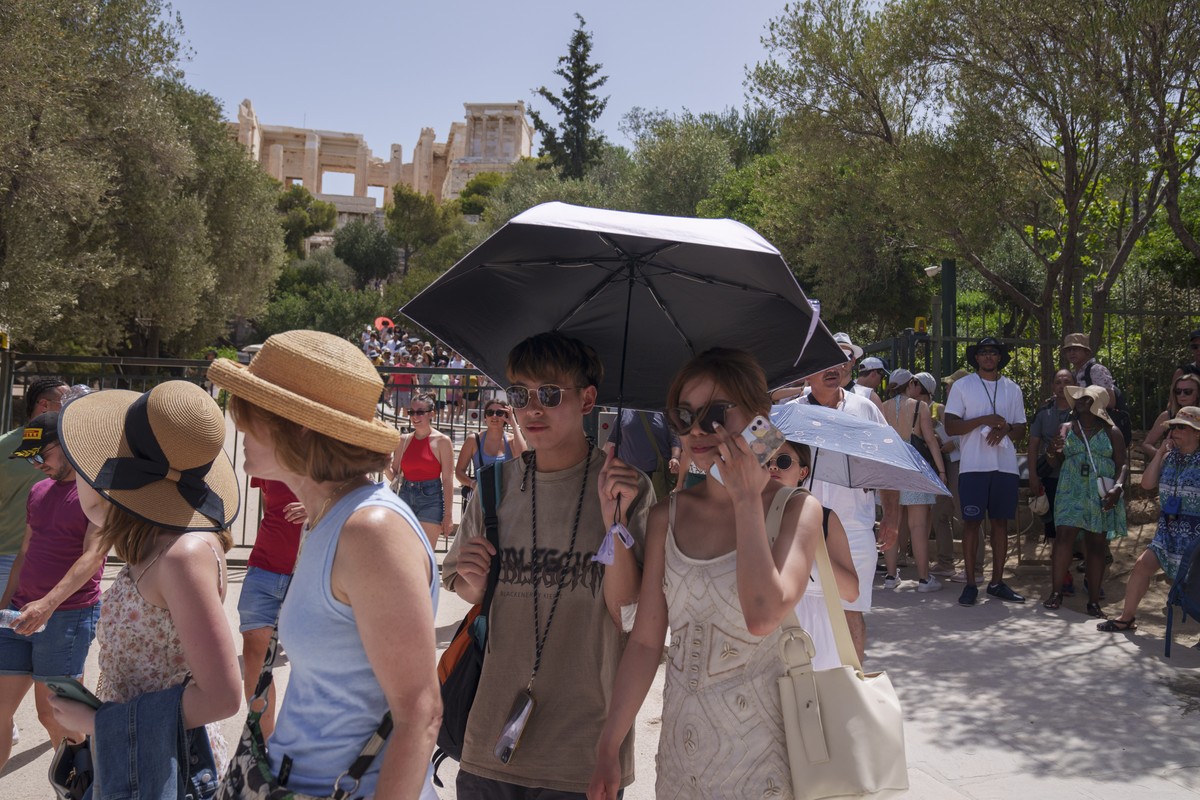Tourists exit the ancient Acropolis in central Athens on Wednesday, June 12, 2024. The ancient site was closed to the public for five hours due to a heat wave that pushed temperatures to 39 degrees Ce ...