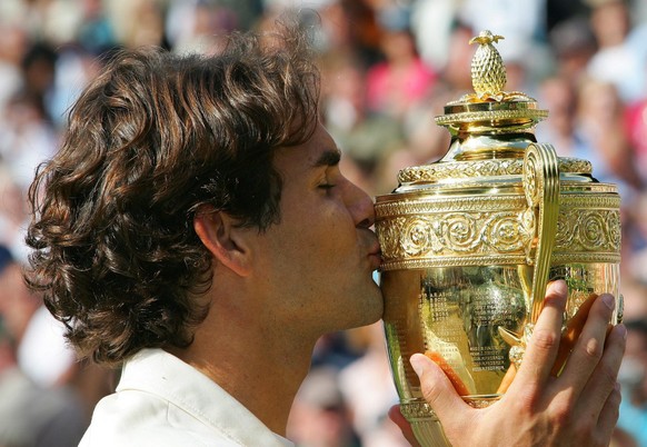Roger Federer of Switzerland kisses the winner&#039;s trophy following his victory over Rafael Nadal of Spain in the men&#039;s final of the Wimbledon Championships at the All England Lawn Tennis Club ...
