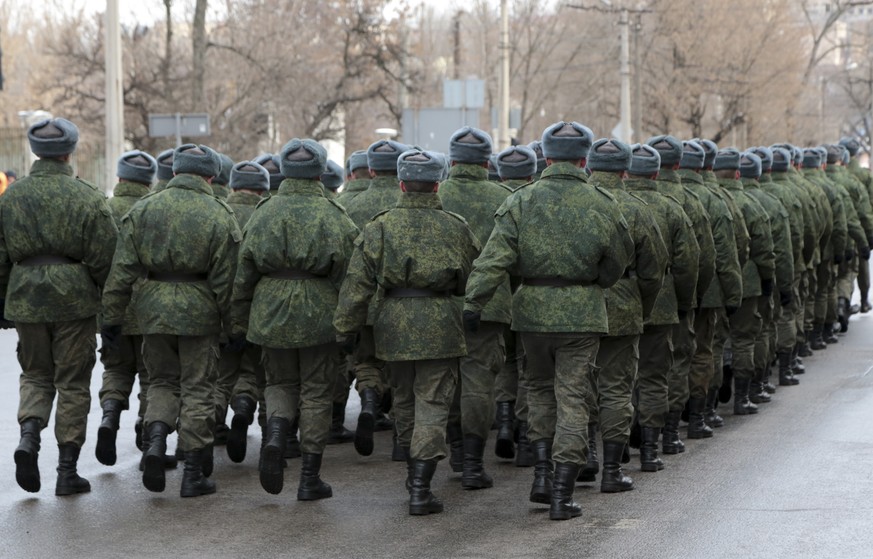 Servicemen march leaving a memorial ceremony to honor the memory of civilians who died during shelling at a crowded bus stop in 2015, in Donetsk, controlled by Russia-backed separatists, eastern Ukrai ...