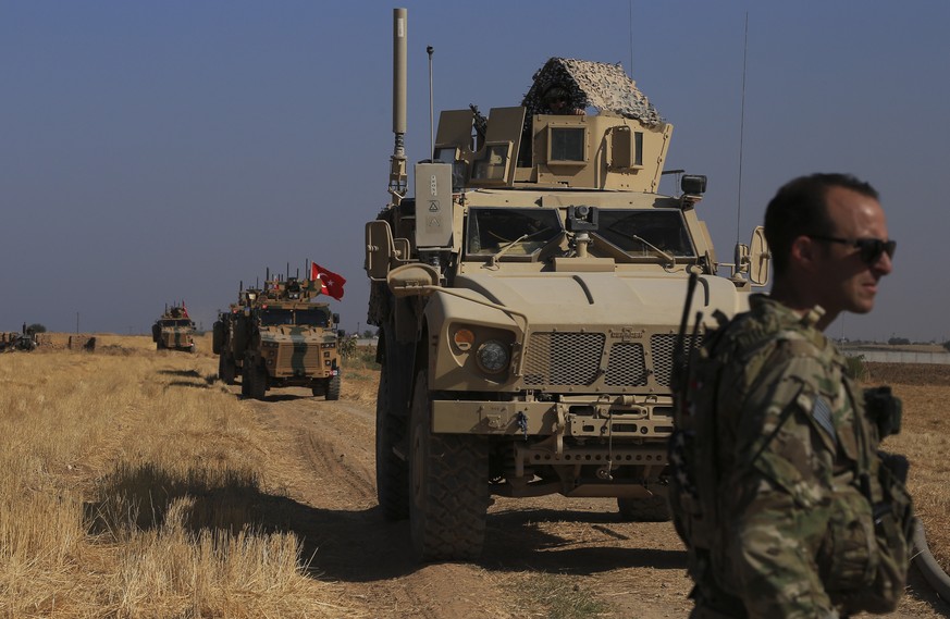 FILE - This Friday, Oct. 4, 2019 file photo, Turkish and American armored vehicles patrol as they conduct joint ground patrol in the so-called &quot;safe zone&quot; on the Syrian side of the border wi ...