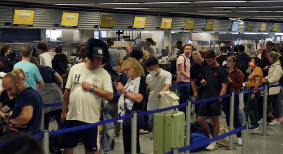 epa10153983 Passengers wait in front of a check-in counters to rebook their flights during a Lufthansa pilots strike, at the international airport in Frankfurt am Main, Germany, 02 September 2022. The ...