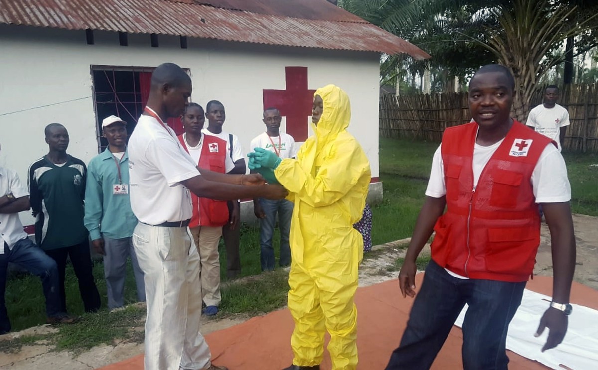 In this photo taken Monday, May 14, 2018, members of a Red Cross team don protective clothing before heading out to look for suspected victims of Ebola, in Mbandaka, Congo. Congo's Ebola outbreak ...