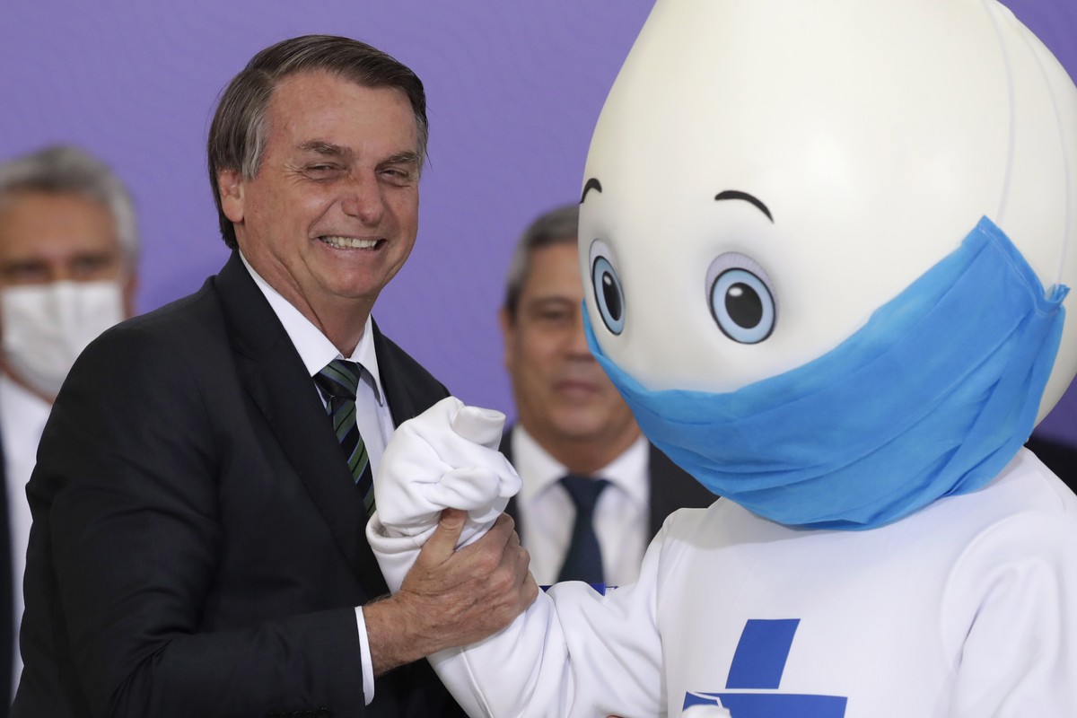 FILE - Brazilian President Jair Bolsonaro poses for photos with the mascot of his nation's vaccination campaign, named "Ze Gotinha," or Joseph Droplet, during a ceremony to present the  ...