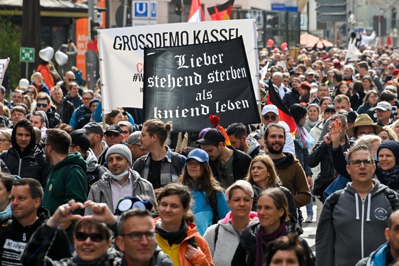 epa09113036 Protesters hold a banner showing in fracture writing ?rather die standing than live kneeling? (front) and another banner reminiscing of a former large-scale demonstration in the German tow ...