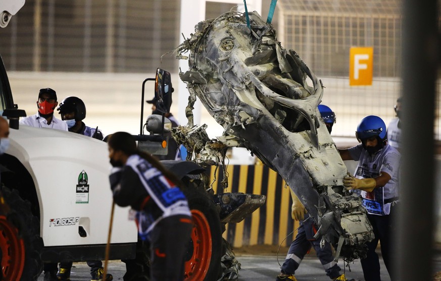 2020 Bahrain GP BAHRAIN INTERNATIONAL CIRCUIT, BAHRAIN - NOVEMBER 29: Marshals remove the wreckage after a huge crash for Romain Grosjean, Haas VF-20, on the opening lap during the Bahrain GP at Bahra ...