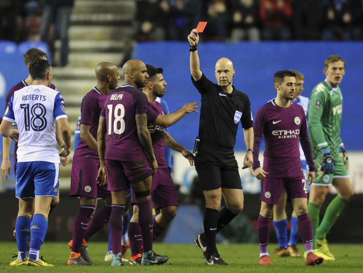 Referee Anthony Taylor shows a red card to Manchester City's Fabian Delph, 18, during the English FA Cup fifth round soccer match between Wigan Athletic and Manchester City at The DW Stadium, Wig ...