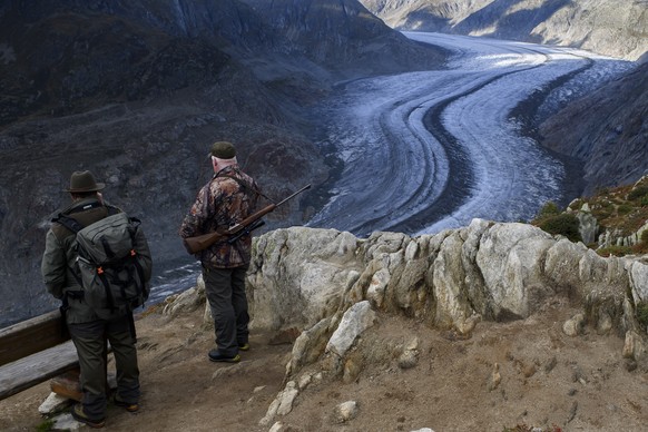 Two Hunters observe the wildlife next to the Swiss Aletsch Glacier during an autumn day above Bettmeralp in Wallis, Switzerland, on Monday, 23 September 2019. The Swiss Aletsch glacier, one of the lar ...